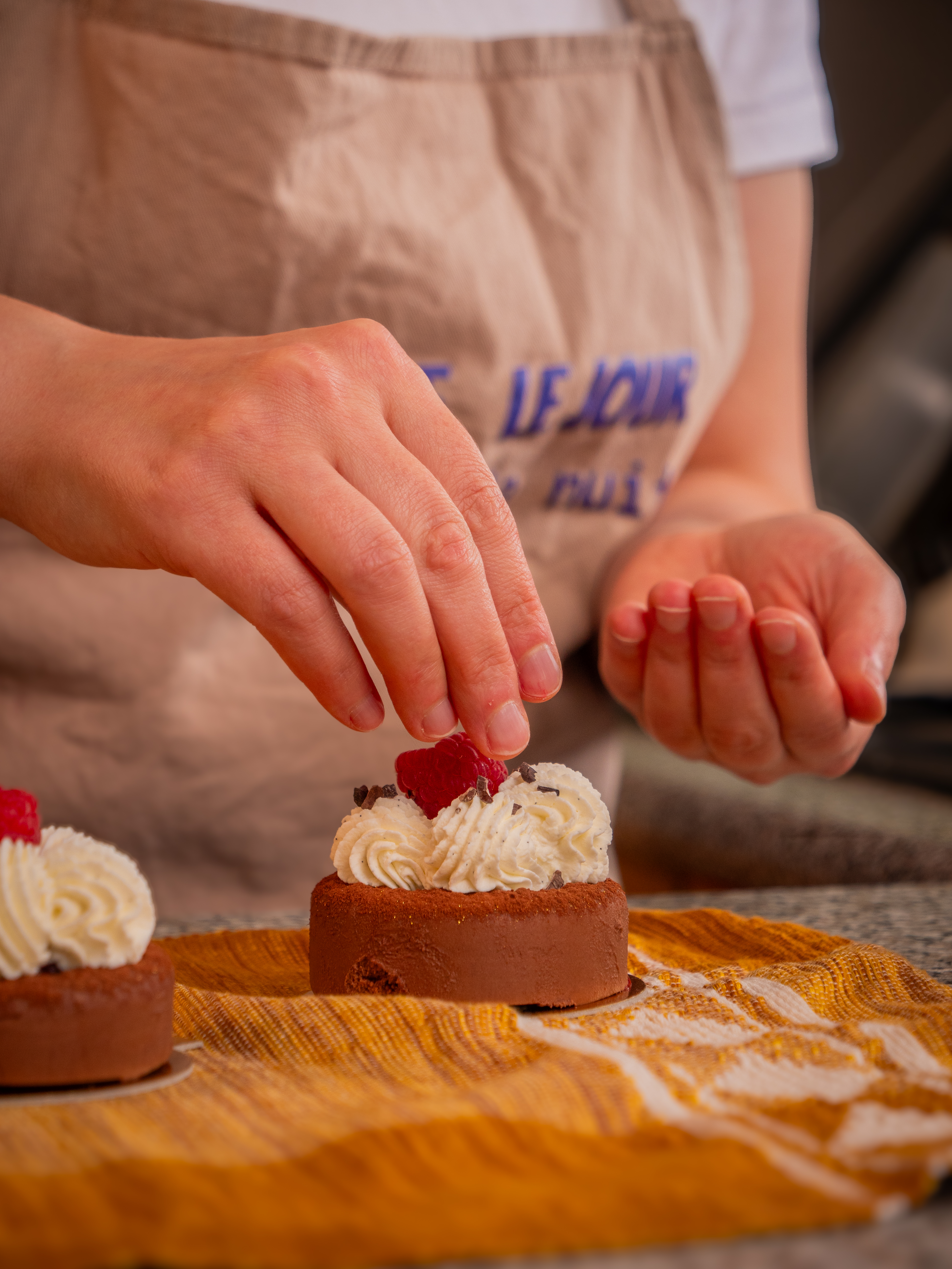 Une framboise déposée sur une tartelette au chocolat et à la crème