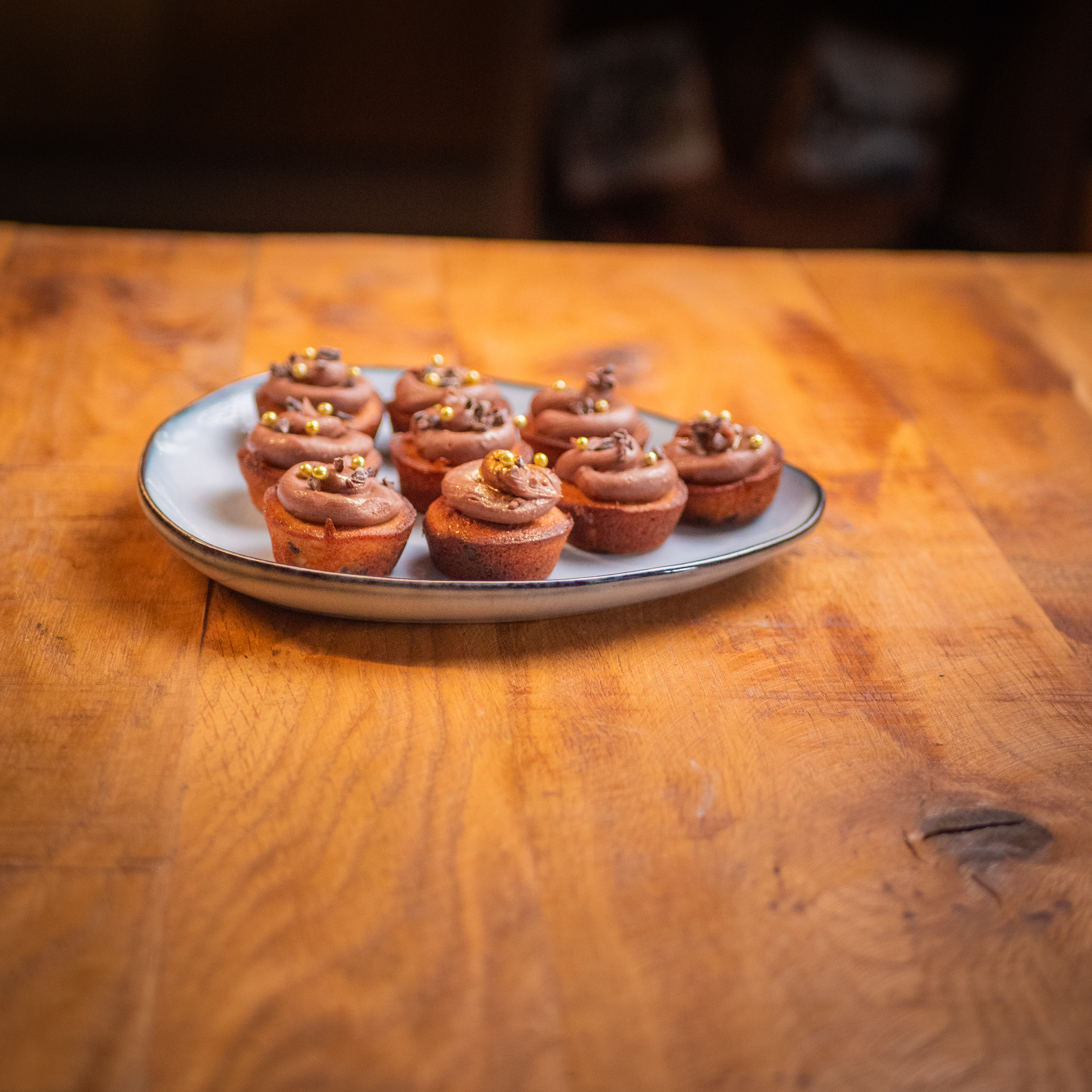 Mini-gâteaux au chocolat surmontés d'une crème au chocolat, sur une table en bois