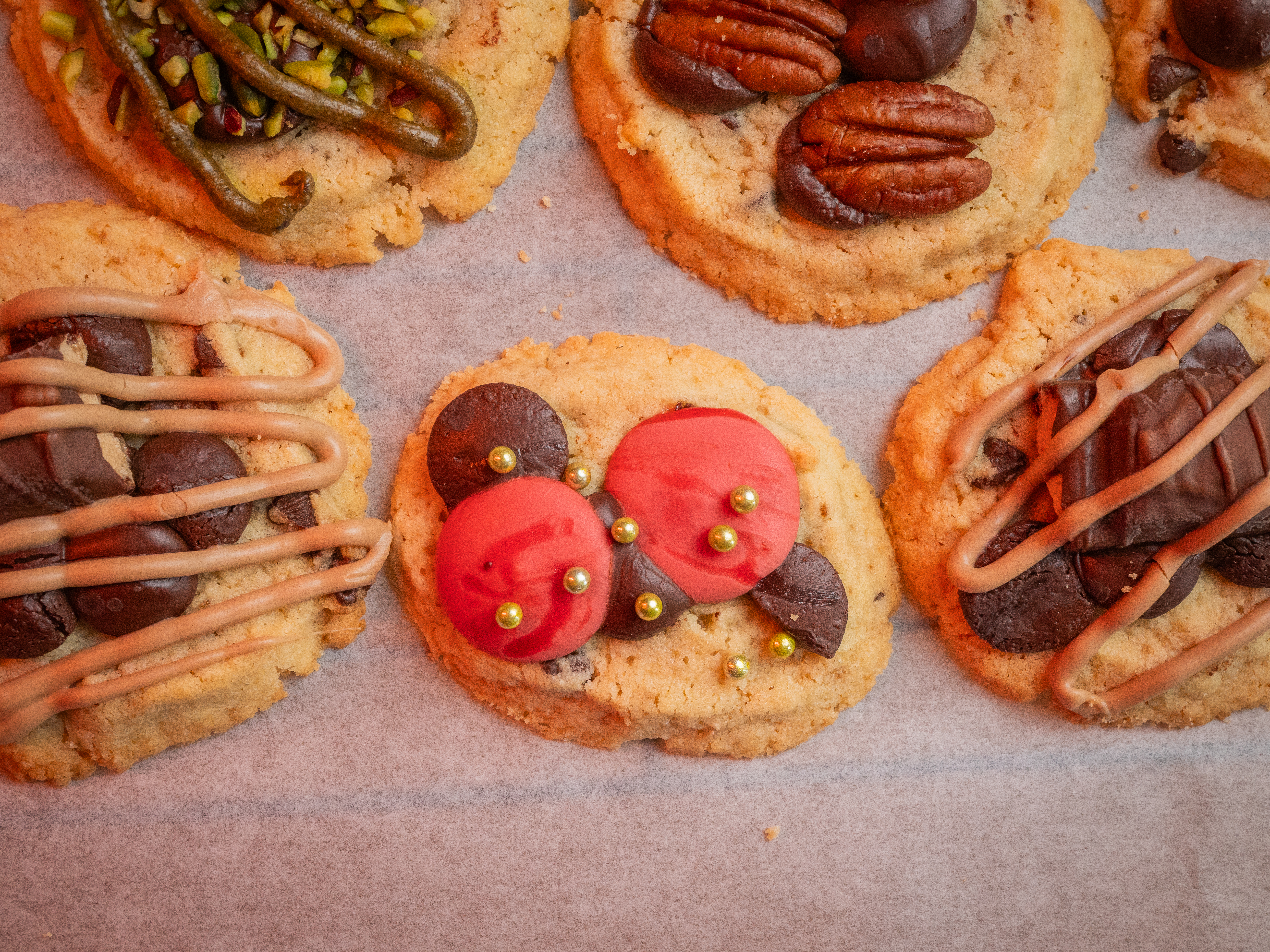 Assortiment de cookies décorés à la pistache, aux noix de pécan et au chocolat, vue du dessus